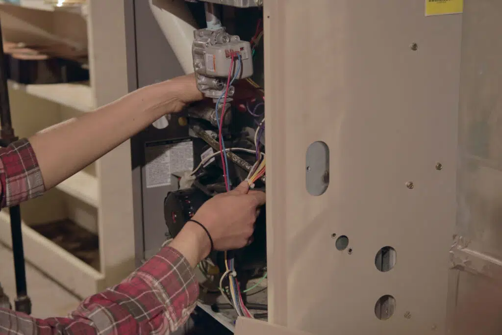 Hands working on furnace