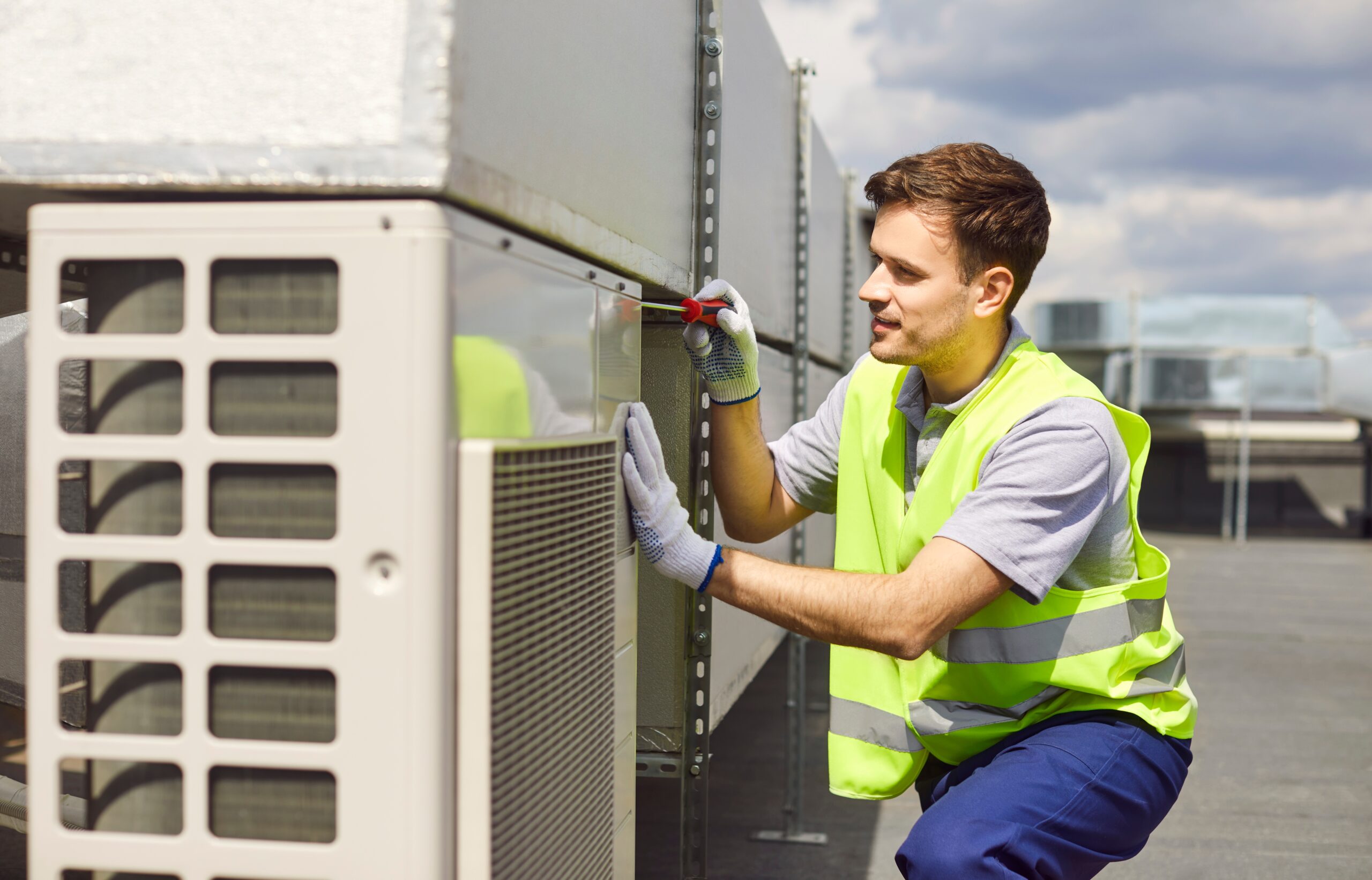 Technician performing AC maintenance service on air conditioner unit