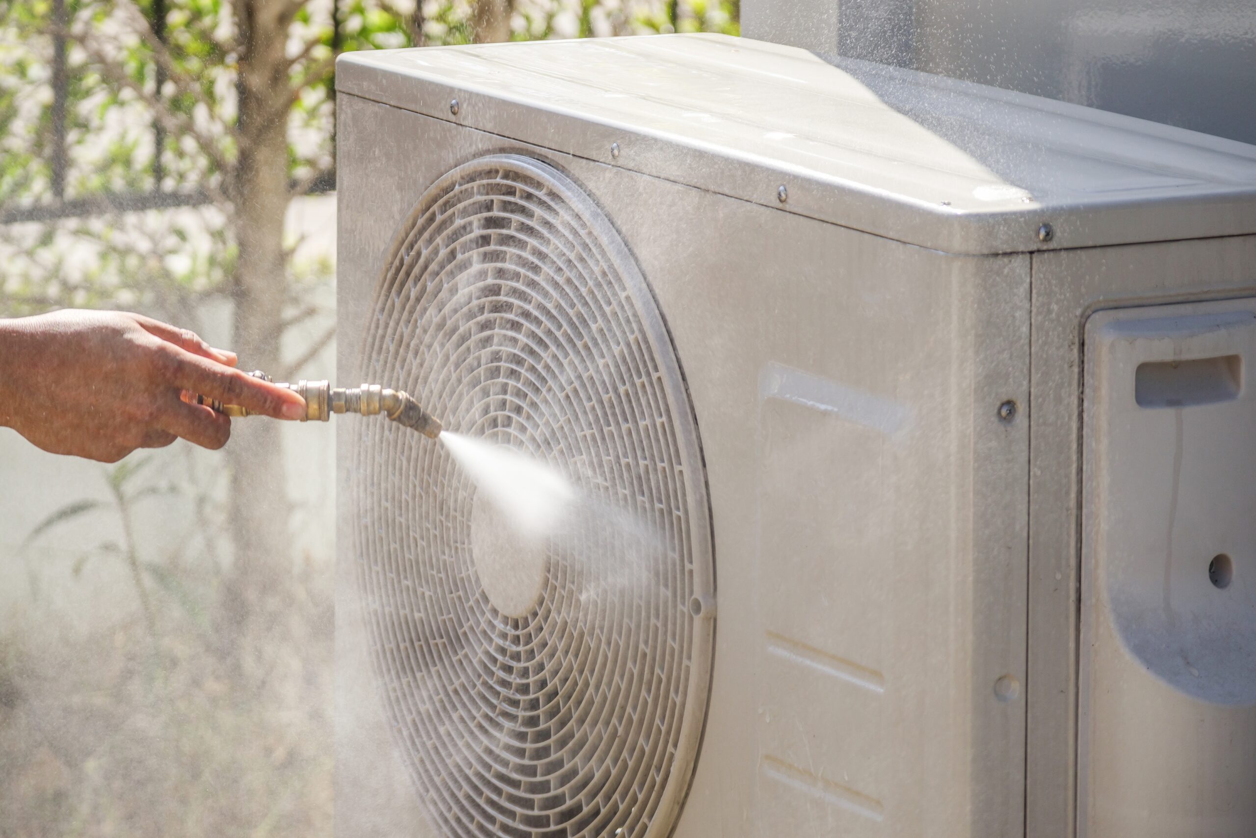 Technician fixing air conditioner after AC stops working during peak heat