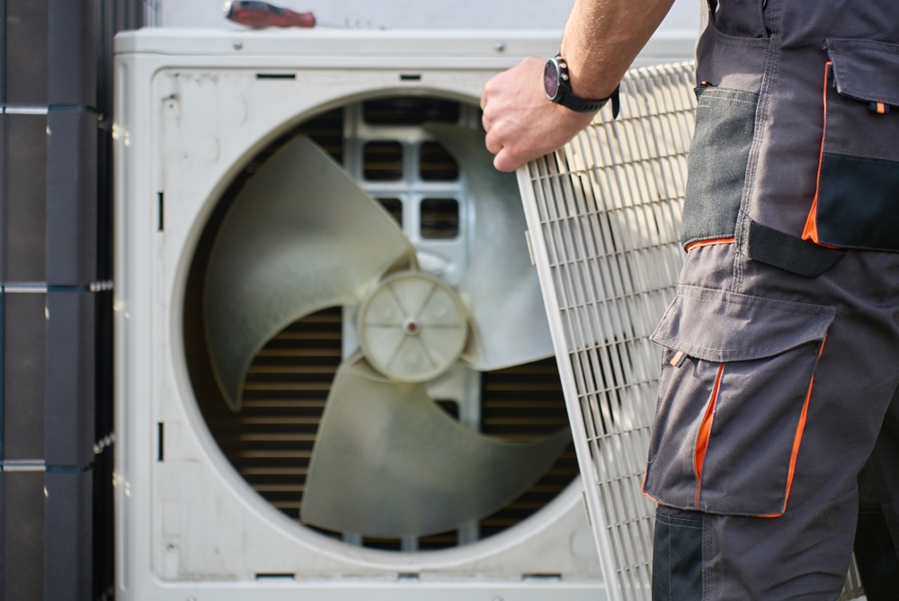 Homeowner troubleshooting an AC not blowing cold air during hot weather
